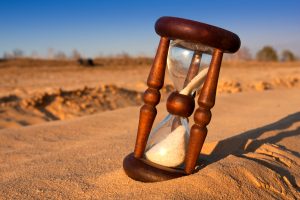 scene with hourglass in desert's sand