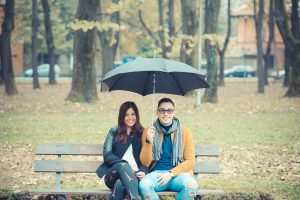 couple on a bench under an umbrella in the park